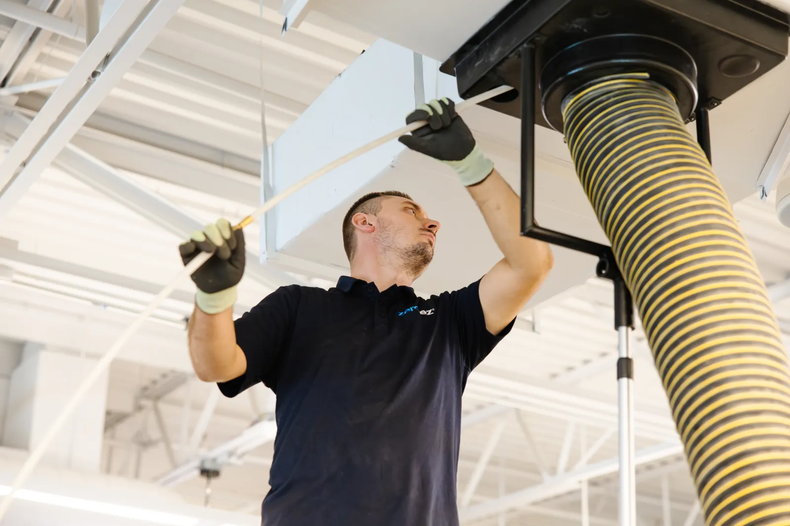 technician cleaning air ducts in commercial building