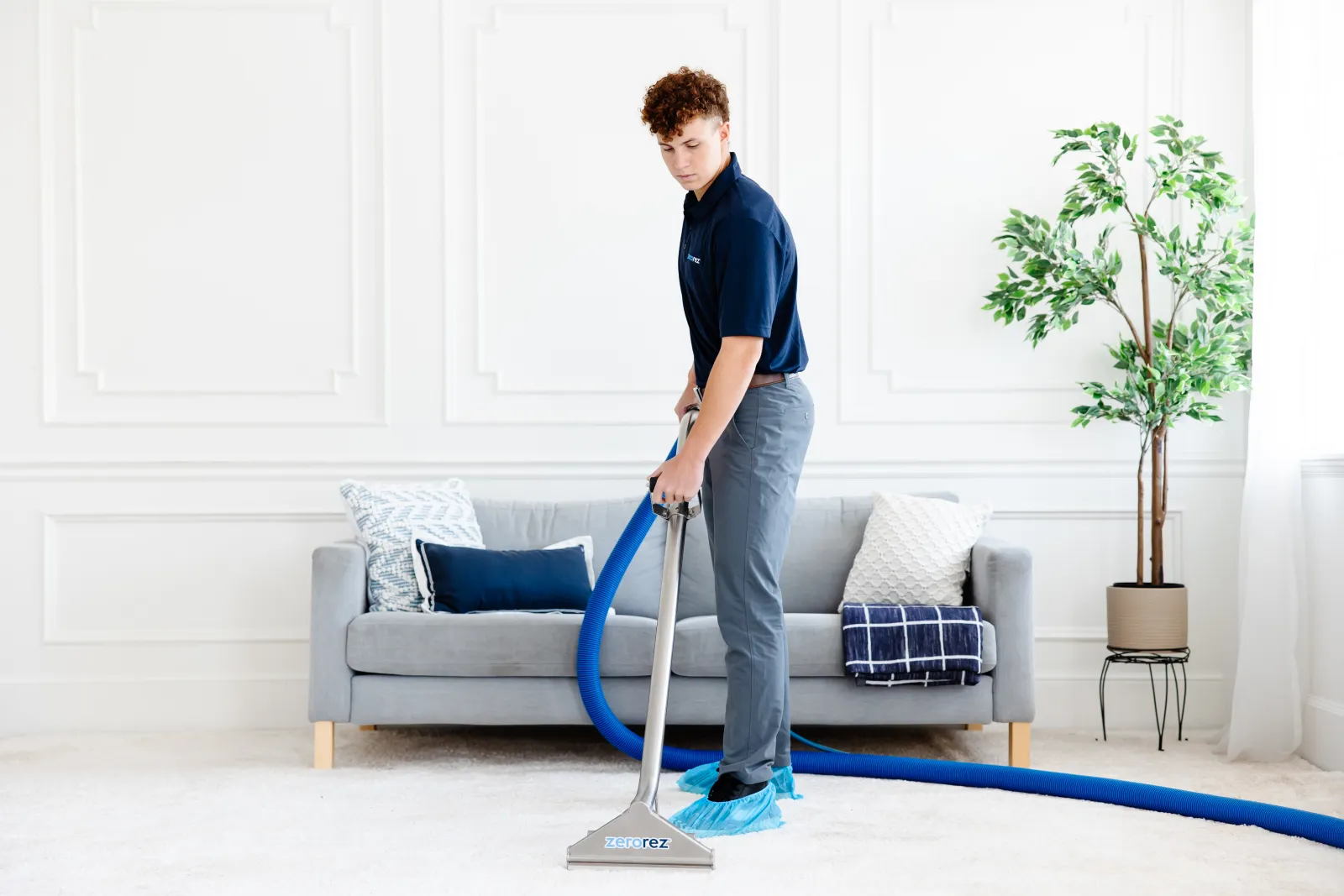 zerorez technician cleaning carpet in living room