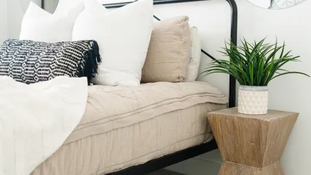 a bed with pillows and a plant